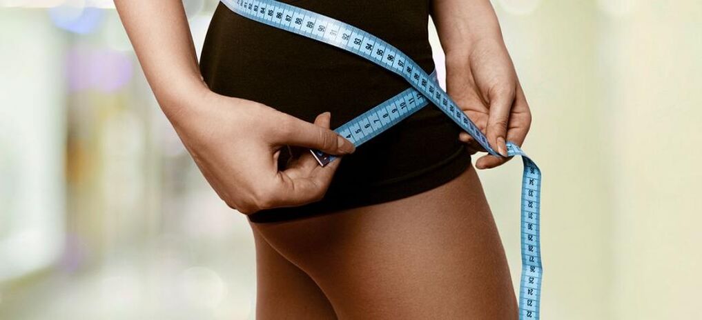 Женщина фиксирует результаты эффективного избавления от лишнего веса